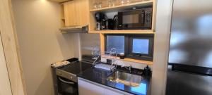 eine Küche mit schwarzer Arbeitsplatte und Mikrowelle in der Unterkunft Alquiler Turistico Centro Villa la Angostura in Villa La Angostura