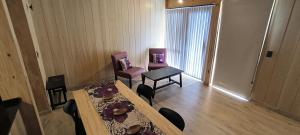 ein Esszimmer mit 2 Stühlen, einem Tisch, einem Tisch und einem Stuhl in der Unterkunft Alquiler Turistico Centro Villa la Angostura in Villa La Angostura
