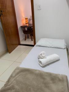 two white towels on a bed in a room at Suíte na Flor de Debora in Alto Paraíso de Goiás +9 photos