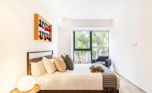 a white bedroom with a bed and a window at Kukun Reforma & Downtown in Mexico City +37 photos