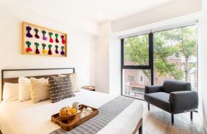 a bedroom with a bed and a chair and a window at Kukun Reforma & Downtown in Mexico City