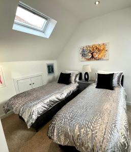 two beds sitting next to each other in a bedroom at Glastonbury Sacred Vault, Split-Level, 1 Bedroom in Glastonbury