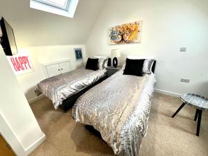 a bedroom with two beds and a painting on the wall at Glastonbury Sacred Vault, Split-Level, 1 Bedroom in Glastonbury +10 photos