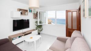 TV a/nebo společenská místnost v ubytování AG Apartamento Nordés Malpica primera línea playa