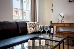a living room with a couch with a cat pillow and wine glasses at Perła Rynku - urokliwy apartament w samym centrum in Wrocław