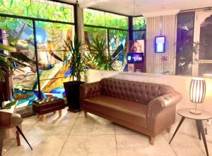 a living room with a couch in front of a mural at Suíte independente apart hotel plaza Elysees 202B in Rio de Janeiro