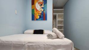 une chambre avec un lit avec un tableau sur le mur dans l'établissement Horizonte Nica Guest House, à San Juan del Sur
