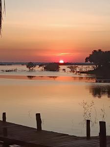 een zonsondergang boven een waterlichaam met een dok bij Santa Helena do inglês in Iranduba