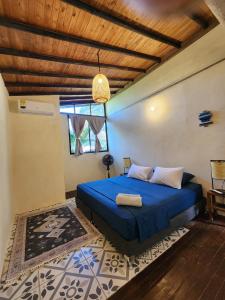 a bedroom with a blue bed and a wooden ceiling at Casas La Floristería in Palomino