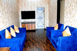 a living room with two blue couches and a flat screen tv at Angels Villa in Mumbai