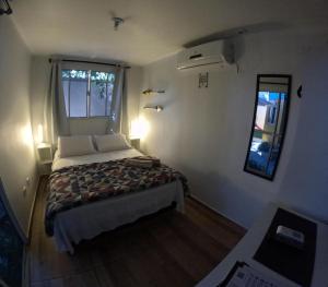 een kleine slaapkamer met een bed en een raam bij Container Hospedaria Paraty in Paraty
