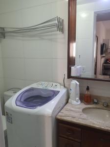 a washing machine sitting on a counter next to a sink at Suíte independente apart hotel plaza Elysees 202B in Rio de Janeiro