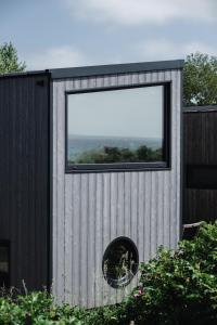 a building with a large window on the side of it at Tiny SeaSide - Loddenhøj in Aabenraa