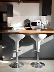 a kitchen with a counter with two bar stools at Los Conejos Bariloche in San Carlos de Bariloche