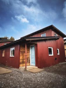 a red building with a blue door on it at Los Conejos Bariloche in San Carlos de Bariloche +4 photos