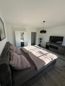 a bedroom with a large bed and a couch at Ferienhaus Heidetraum Lüneburger Heide in Munster im Heidekreis