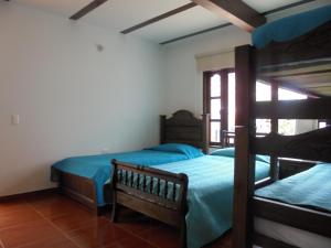 a bedroom with two bunk beds and a window at Hospederia Villa Berenita in Villa de Leyva