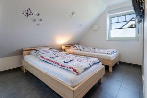 2 camas en una habitación con mariposas en la pared en Kranichresidenz, en Hohwacht 37 fotos más