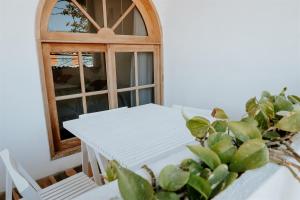 奥尔沃克斯岛Apartments & Suites MADRE Holbox Self-Check IN的白色桌子、椅子和窗户