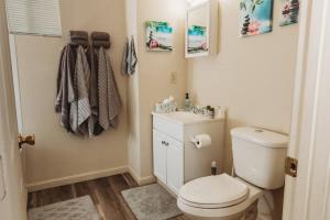 a bathroom with a white toilet and a sink at Tranquil Family Home Near BWI Casino Shopping & Fire Pit in Severn +24 photos
