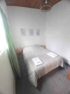 a bedroom with a bed with two towels on it at Casita Las Lavandas in El Bolsón