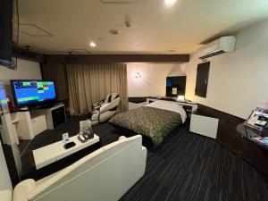 a hotel room with a bed and a flat screen tv at ホテル ウィズ男塾ホテルグループAdult Only in Fukuyama