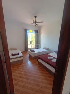 een kamer met drie bedden en een raam bij Residence Hotel Efrata Centro Itaborai in Itaboraí +18 foto's