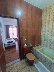 een badkamer met toilet en ligbad bij Residence Hotel Efrata Centro Itaborai in Itaboraí