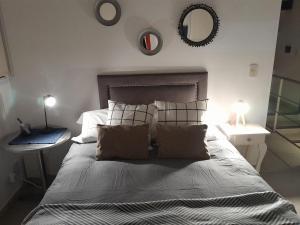 a bedroom with a bed with pillows and a mirror at Duplex en salta in Destilería Chachapoyas