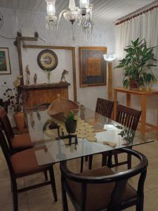 a dining room with a glass table and chairs at Pousada Casa Jardim in Serra Negra +119 photos