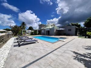 a backyard with a swimming pool and a house at Villa familiale, piscine privée, classée 3 étoiles in Sainte-Rose