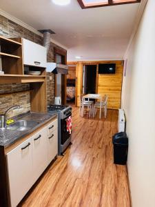 a kitchen with a sink and a stove at Departamento Marve in Puerto Natales