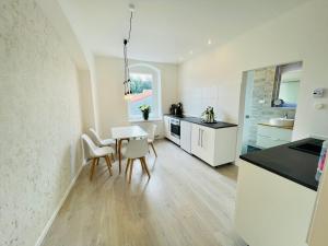 a kitchen and dining room with a table and chairs at Zentrale moderne Unterkunft mitten in Meissen No 2 in Meißen