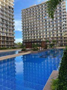a large swimming pool in front of a large building at Balay-Balay Condotel in Lapu Lapu City