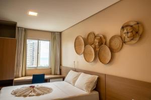 a hotel room with a bed and baskets on the wall at Fortaleza Mar Hotel in Fortaleza