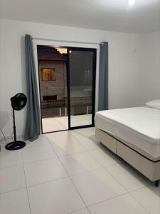 a bedroom with a bed and a large window at Flats super bem localizado! in Arraial do Cabo +16 photos