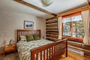 een slaapkamer met een houten bed en een raam bij Nakiska Bear Ranch in Clearwater