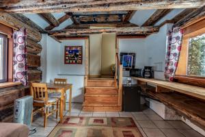 a room with a table and a kitchen with wooden ceilings at Nakiska Bear Ranch in Clearwater