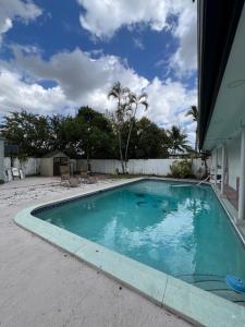 a swimming pool with blue water in a yard at AMIRI Hollywood 5 mins from Hard Rock Stadium & The Guitar in Hollywood