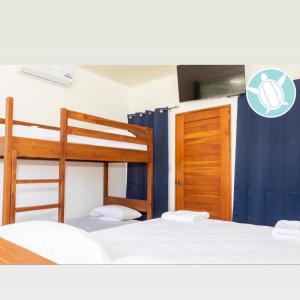 a bedroom with two bunk beds and a window at Villa Tortuga San Juan del Sur in San Juan del Sur