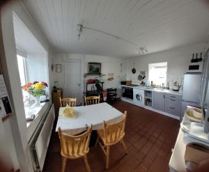 een keuken met een tafel en stoelen in een kamer bij Quarvue Farmhouse, Unique house with views of Mournes and Cooleys in Ó Méith