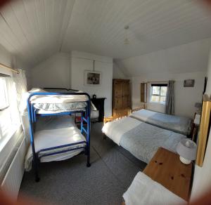 een slaapkamer met twee stapelbedden en een raam bij Quarvue Farmhouse, Unique house with views of Mournes and Cooleys in Ó Méith