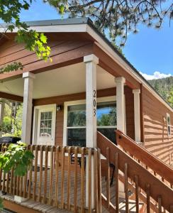 a house with a porch with a fence at Yogi Bear's Jellystone Park Camp-Resort in Estes Park in Estes Park