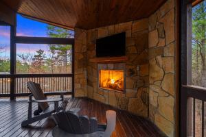 a living room with a fireplace in a stone wall at Magnolia Peak By The Cohost Company in Broken Bow