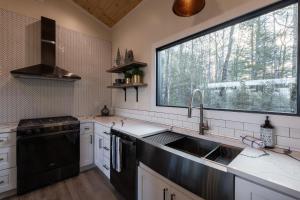 a kitchen with a sink and a large window at A Red River Barnhouse in Rogers +32 photos