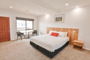 une chambre avec un lit et une table avec des chaises dans l'établissement Robinvale Golf Club Resort, à Robinvale 