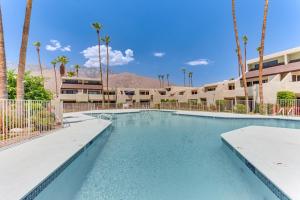 a swimming pool at a resort with palm trees at Mtn-View Condo with Pool Access in Palm Springs! in Palm Springs