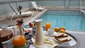 a table with breakfast foods and drinks next to a swimming pool at Hotel Posada La Comandancia in Melo