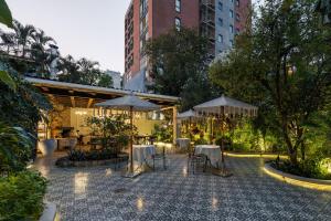 a patio with tables and umbrellas in a courtyard at Villa Ganz Boutique Hotel in Guadalajara