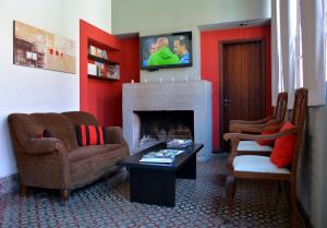 a living room with two chairs and a fireplace at Hotel Posada La Comandancia in Melo